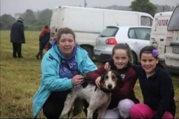 Liz Kenny with her daughter Jade and friend Niamh embracing with Ms. Hotfoot a dog that was named after one of the late John Kennys good dogs